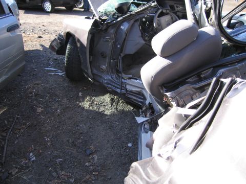 1991 Ford LTD Crown Victoria - The interior of a heavily damaged car is visible, with torn seats and an open door.