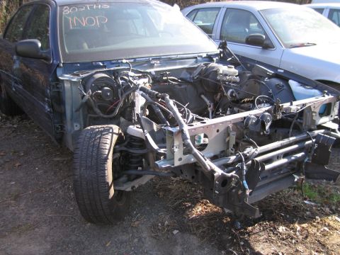 1991 Ford LTD Crown Victoria - This vehicle is missing its front end, exposing the engine and wiring. Text on the windshield reads 'INOP'.