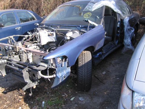 1991 Ford LTD Crown Victoria - This blue sedan has significant front-end damage, with the grille and hood removed.