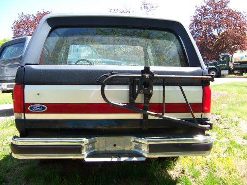1987 Ford Bronco - Rear view of a 1987 Ford Bronco showing its spare tire carrier and distinctive body stripes.