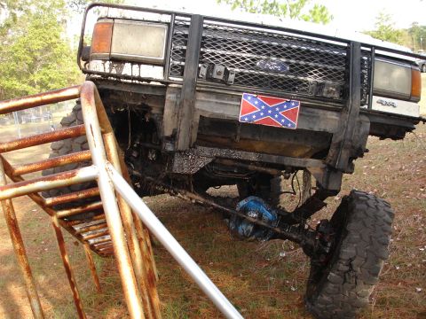 1989 Ford Bronco - This 1989 Ford Bronco features extensive off-road modifications and a prominent Confederate flag sticker on its grille guard.