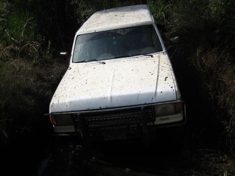 1989 Ford Bronco - This 1989 Ford Bronco appears to be stuck in a muddy, overgrown area.