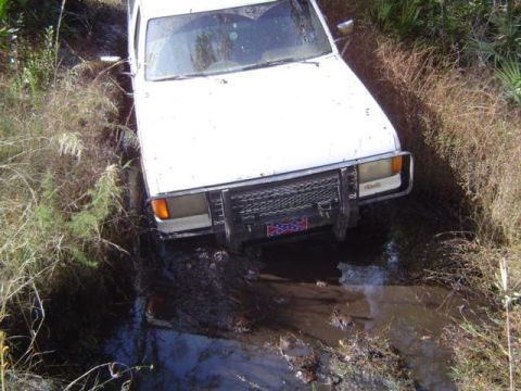 1989 Ford Bronco - This vehicle appears to be stuck in a muddy, overgrown area, possibly off-roading.