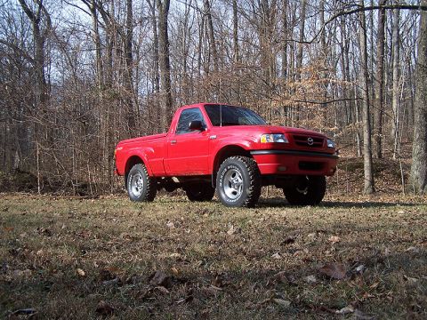 2001 Mazda B3000 - Red 2001 Mazda B3000 pickup truck sits in a wooded area.
