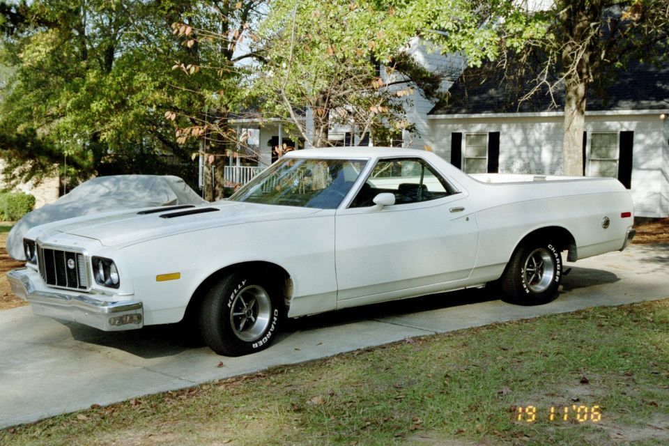 White Ford Ranchero pickup, 3/4 front view, on driveway with mag wheels and white-letter tires