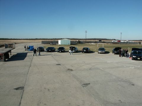 2001 Mercury Grand Marquis - A group of cars and people gather on a clear day at an outdoor event.