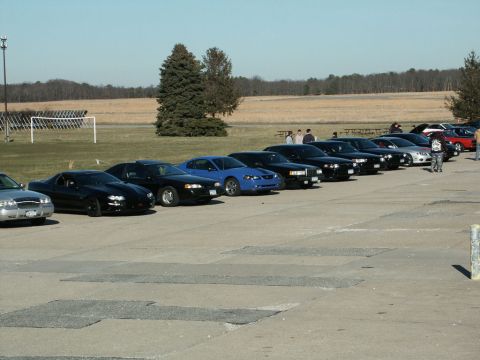 2001 Mercury Grand Marquis - A collection of cars, including sedans and coupes, are parked in a line on a sunny day.