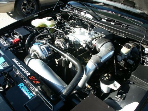 2001 Mercury Grand Marquis - The engine bay features a supercharger and custom intake piping, with visible branding on a black cover.