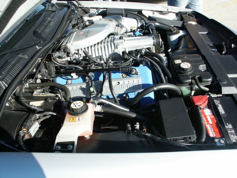Supercharged V8 engine with blue valve covers and silver intake manifold