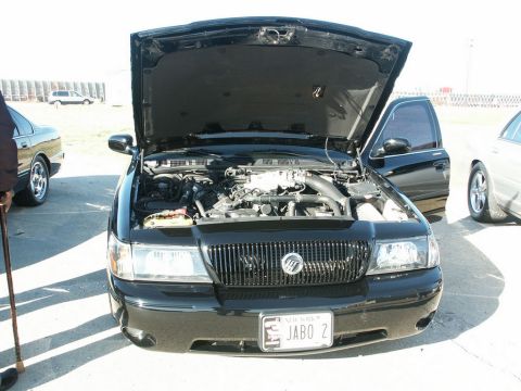 2001 Mercury Grand Marquis - Front view of a black 2001 Mercury Grand Marquis with its hood and driver's door open, revealing the engine compartment.