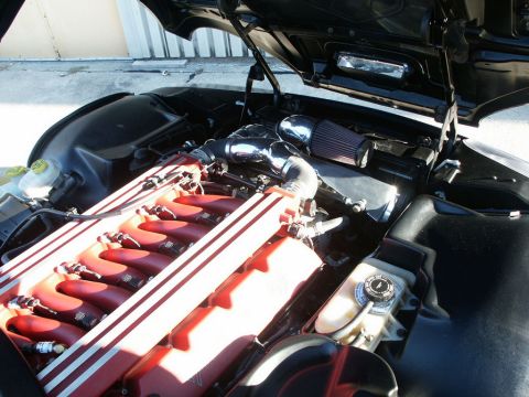 2001 Mercury Grand Marquis - Close-up of a vehicle's engine bay, highlighting the red intake manifold and chrome air intake system.