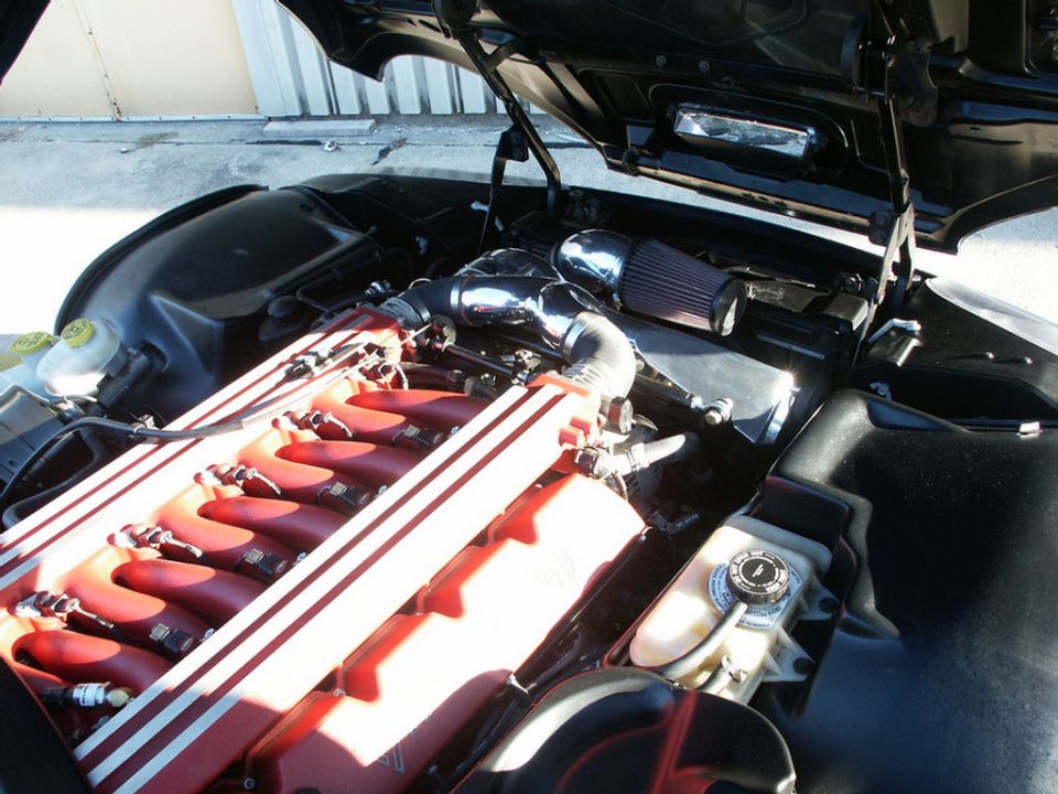 Engine bay with red intake manifold and chrome air intake