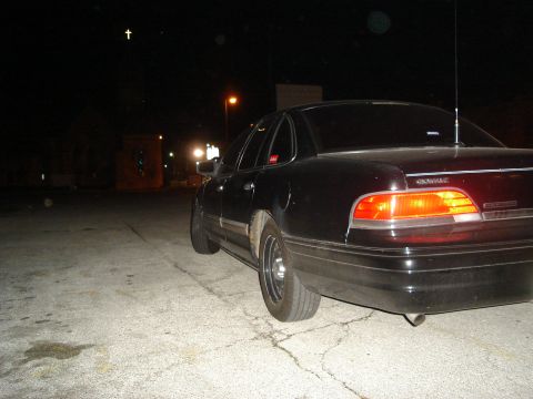 1992 Ford Crown Victoria - Rear view of a black 1992 Ford Crown Victoria parked on asphalt at night.