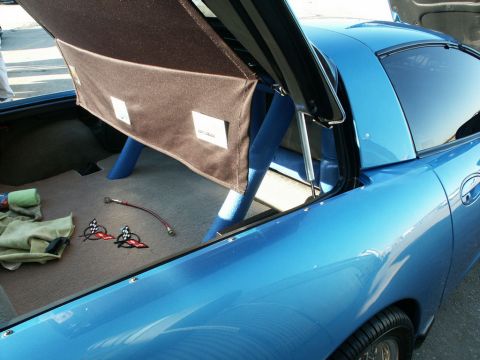 2001 Mercury Grand Marquis - Interior view of a blue sports car, with trunk open, revealing checkered flag emblems.