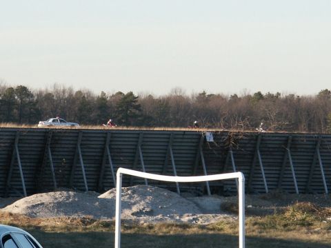 2001 Mercury Grand Marquis - Police car and dirt bikes are visible on a raised road with a wooden barrier below.