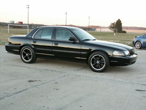 2001 Mercury Grand Marquis - A black 2001 Mercury Grand Marquis is parked outside with a soccer field in the background.