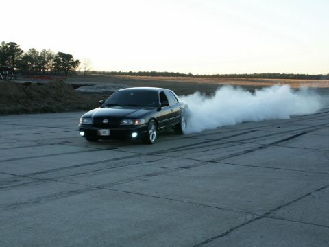 2001 Mercury Grand Marquis - A black 2001 Mercury Grand Marquis performs a burnout, creating a large cloud of smoke.