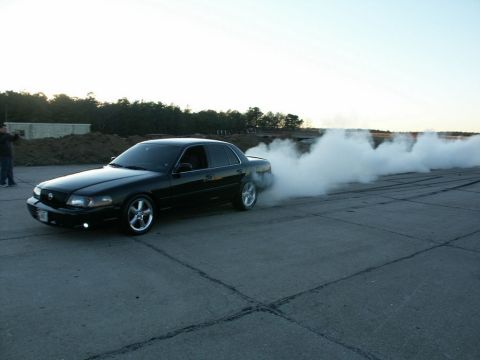 2001 Mercury Grand Marquis - Black 2001 Mercury Grand Marquis performing a burnout on a paved surface.