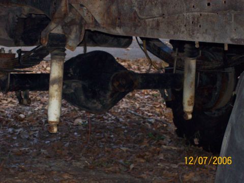 1978 Ford Bronco - Close-up view of the rear axle and suspension components of a vehicle, showing signs of rust and wear.