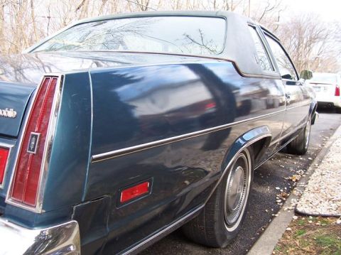 1999 Ford Crown Victoria - Rear quarter panel and side view of a 1977 Oldsmobile Delta 88 Royale coupe.