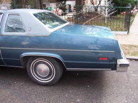1999 Ford Crown Victoria - This sedan features a two-tone paint scheme with a vinyl top and a prominent chrome bumper.