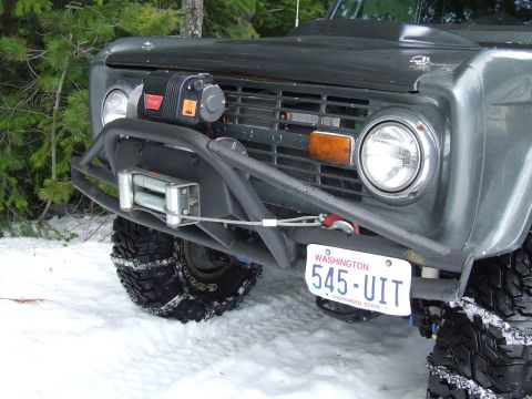1976 Ford F-150 - Modified 1976 Ford Bronco front end with winch and brush guard in a snowy environment.
