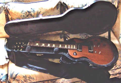 1978 Ford Bronco - Electric guitar resting inside its protective case on a patterned couch.