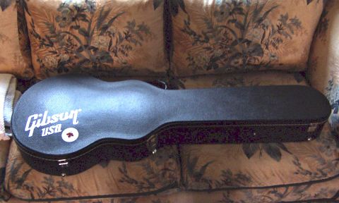 1978 Ford Bronco - A black Gibson USA guitar case rests on a floral-patterned couch.