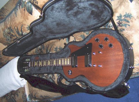 1978 Ford Bronco - An electric guitar rests in its open case, displayed against a patterned couch.