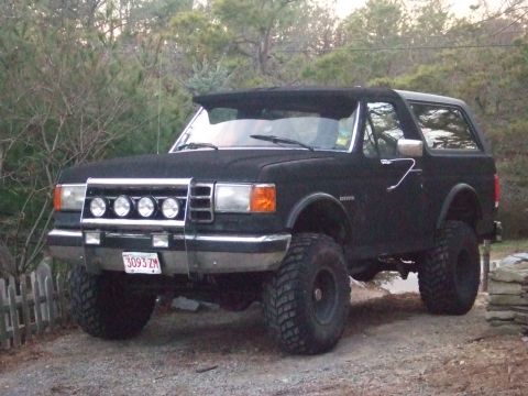 1995 Ford Mustang - This lifted black Ford Bronco features an aggressive stance with large off-road tires and a custom front light bar.