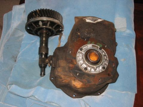 1991 Ford Bronco - A transfer case and its associated output shaft with a gear are shown resting on a blue cloth.