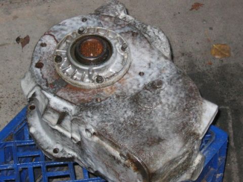 1991 Ford Bronco - A dirty transfer case, possibly from a 1991 Ford Bronco, sits on a blue plastic crate.