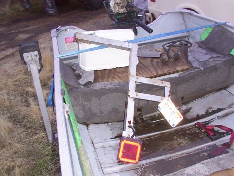 2003 Ford Ranger - The interior of a small boat is shown, an outboard motor and a license plate.