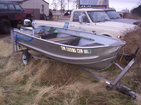 2003 Ford Ranger - A boat on a trailer is parked in a yard with several trucks visible in the background.