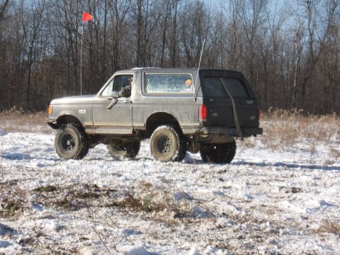 1979 Ford Bronco - This SUV, likely from the early 1980s, navigates a snowy, wooded terrain.