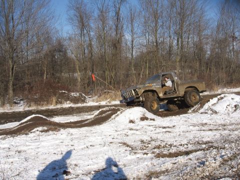 1979 Ford Bronco - This modified truck is navigating a challenging off-road course in snowy conditions.