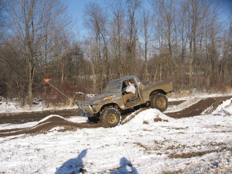 1979 Ford Bronco - A lifted Ford Bronco navigates a snowy and muddy off-road course.