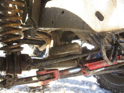 1979 Ford Bronco - Close-up view of the suspension and steering system on a modified off-road vehicle.
