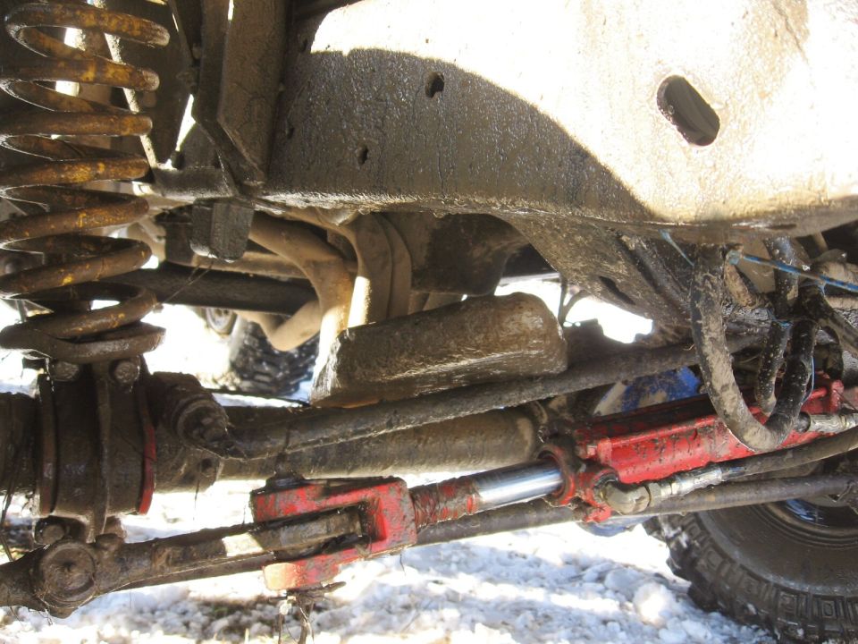 Off-road vehicle suspension with red steering stabilizer and rusty springs