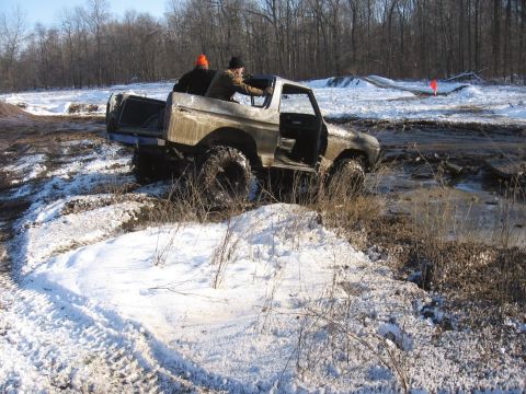 1979 Ford Bronco - Two people are in a Ford Bronco that is stuck in mud and snow during an off-road excursion.