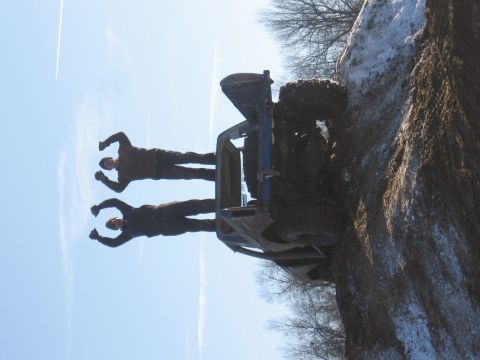 1979 Ford Bronco - An off-road vehicle has rolled onto its side on a muddy, snow-dusted embankment.