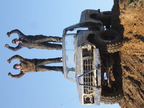 1979 Ford Bronco - This 1979 Ford Bronco is stuck in the mud, with two people posing on its side.