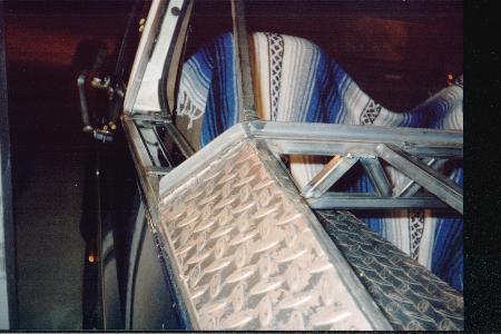 1990 Ford Bronco - Custom metal fabrication is visible inside a vehicle, with a striped blanket draped over a seat.