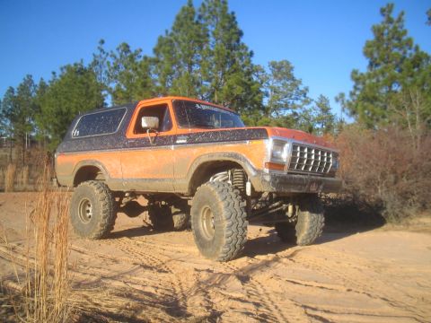 1979 Ford Bronco - This lifted Ford Bronco is shown off-roading on a sunny day.