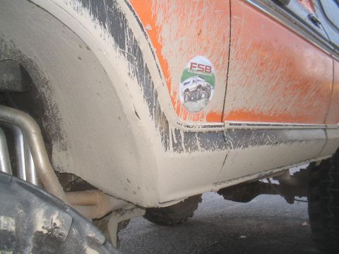 1979 Ford Bronco - Mud-covered orange SUV with a prominent FSB sticker on the side panel.