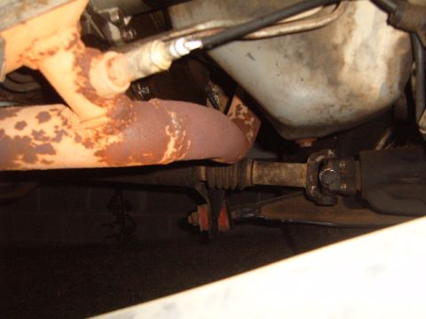 1988 Ford Bronco - Close-up of vehicle undercarriage showing exhaust components and driveshaft, with a watermark at the bottom right.