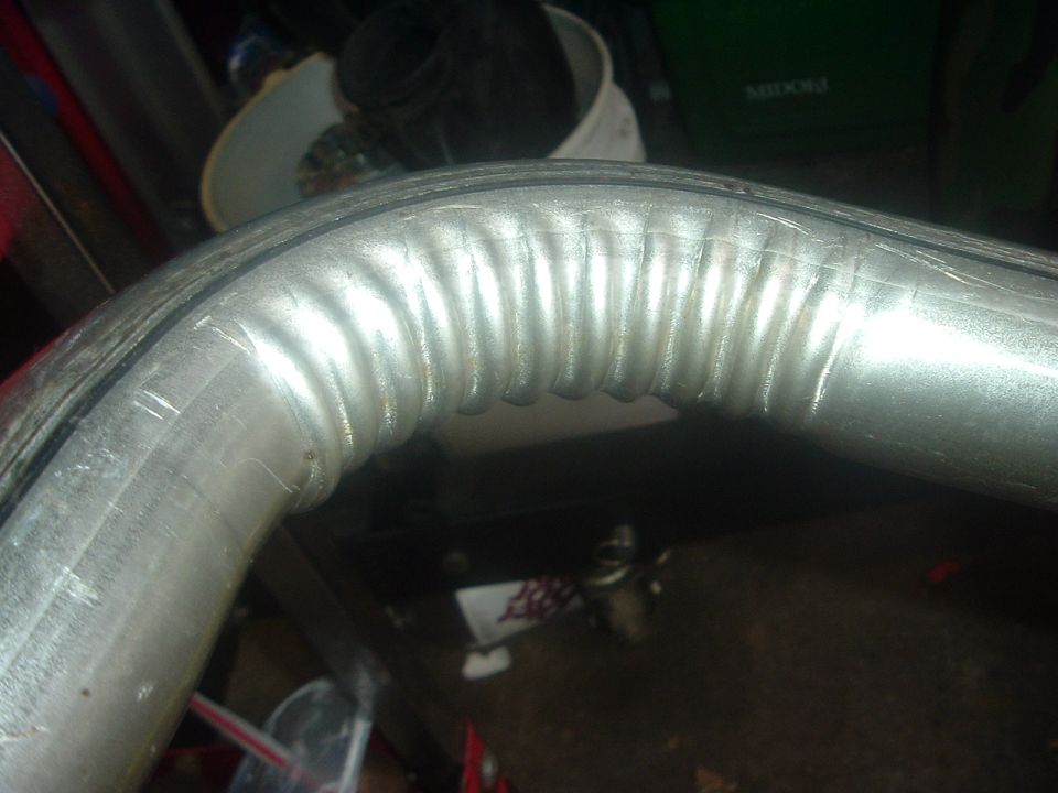 Corrugated metal exhaust pipe with a black rubber seal