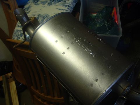 1989 Ford Escort - A metal exhaust muffler is shown with stamped text indicating its country of origin.