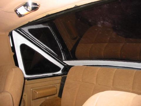 1990 Ford Bronco - Interior view of a vehicle showing tan seats and a dark tinted rear window.