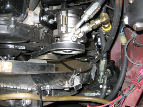 1987 Suzuki Samurai - Close-up view of the power steering pump and associated hoses and belts within an engine bay.